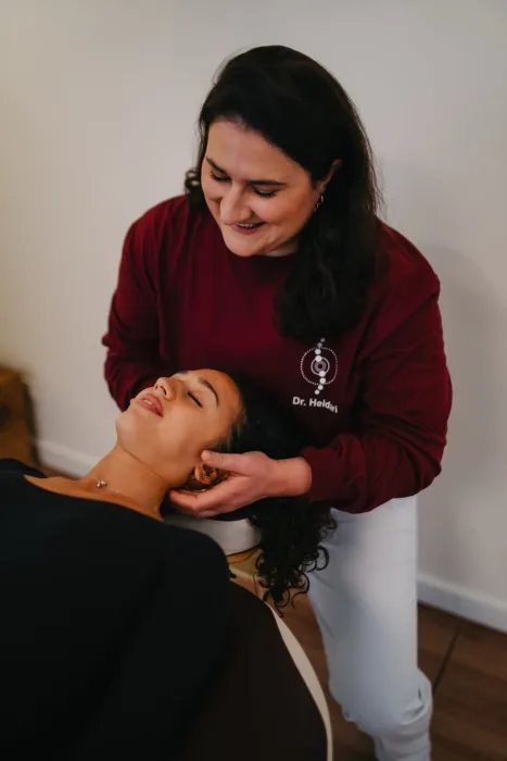 Dr. Nika Heidari behandelt den Nacken einer liegenden Patientin